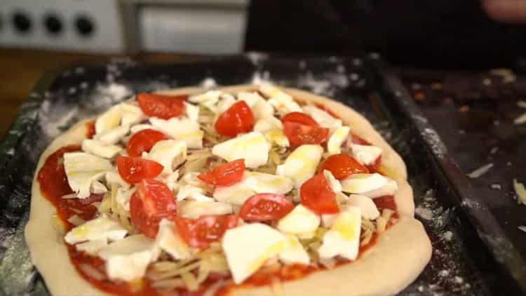 Para hacer una pizza clásica, ponga el relleno sobre la masa.