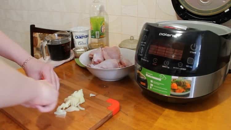 Pour faire cuire un lapin dans une cocotte dans une sauce à la crème sure, hachez l'oignon