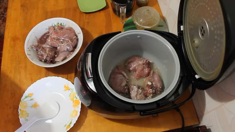 Faire cuire un lapin dans une mijoteuse dans une sauce à la crème sure, faire frire la viande