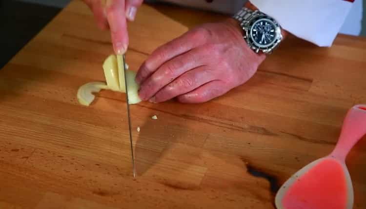 To cook a rabbit with potatoes in a slow cooker, chop the onion