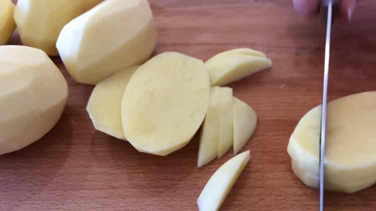 Da biste kuhali pileća prsa s krumpirom u pećnici, nasjeckajte krumpir
