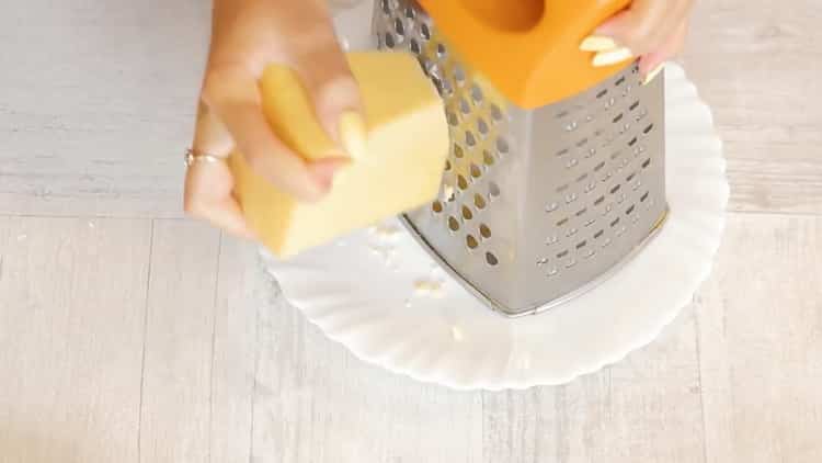 Para preparar un pastel con pollo y champiñones, rallar el queso