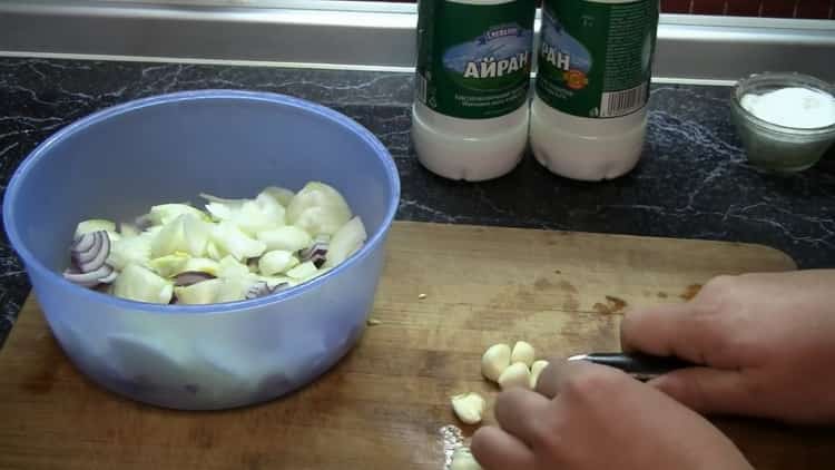 Upang lutuin ang kuneho na atsara sa oven, i-chop ang bawang