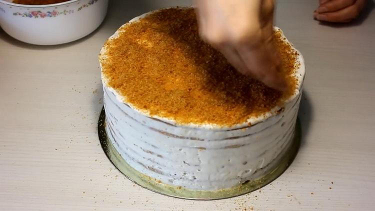 Da biste napravili kolač od meda sa kiselim vrhnjem, pospite koru mrvicama
