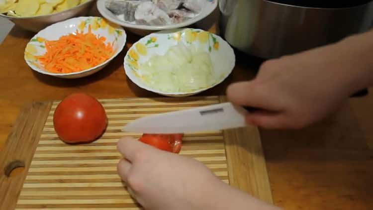 Para cocinar el abadejo en una olla de cocción lenta, corte los tomates.