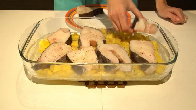 Para cocinar el fletán en el horno, ponga el pescado sobre las papas.