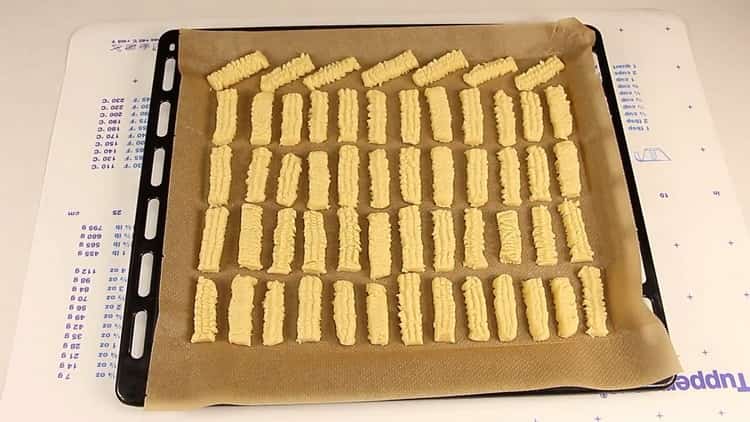 To cook shortbread cookies through a meat grinder, preheat the oven