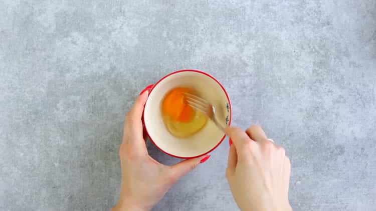 Battre les œufs pour faire des biscuits à partir de fromage fondu.