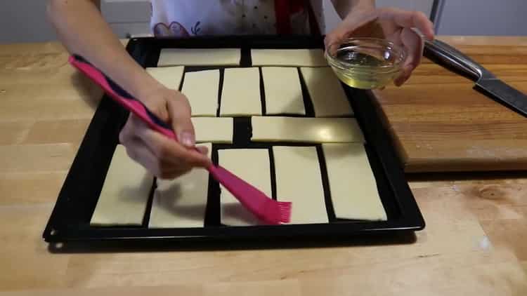 To make cookies from puff pastry, grease the dough