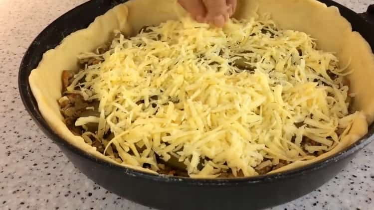 Para hacer un pastel en una sartén, espolvorea el relleno con queso