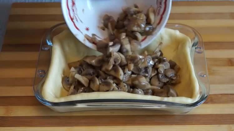 To make a pie with mushrooms in the oven, put the filling on the dough