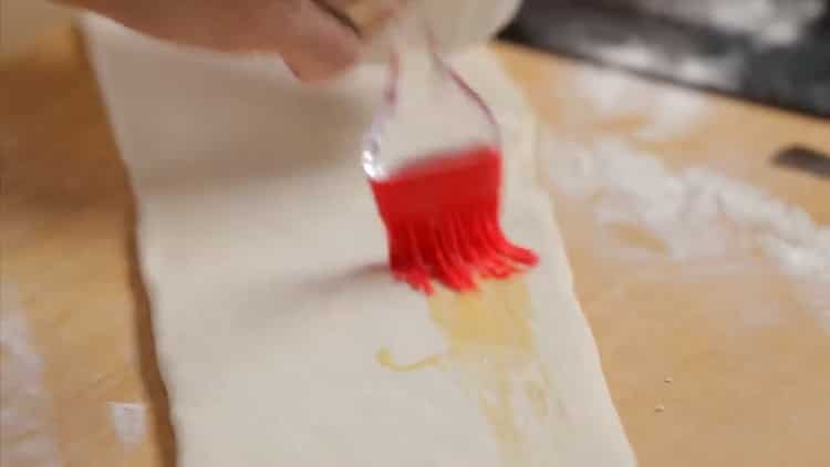 Pour faire une tarte au poulet et aux champignons, graissez la pâte avec un œuf