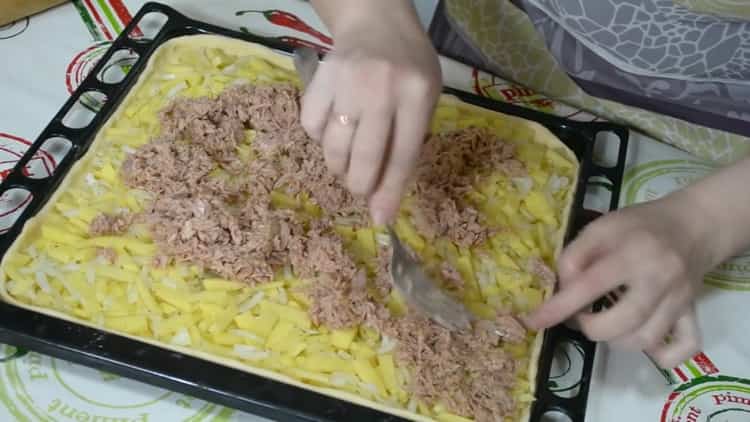 Pour préparer une tarte avec du poisson et des pommes de terre, mettez tous les ingrédients sur la pâte