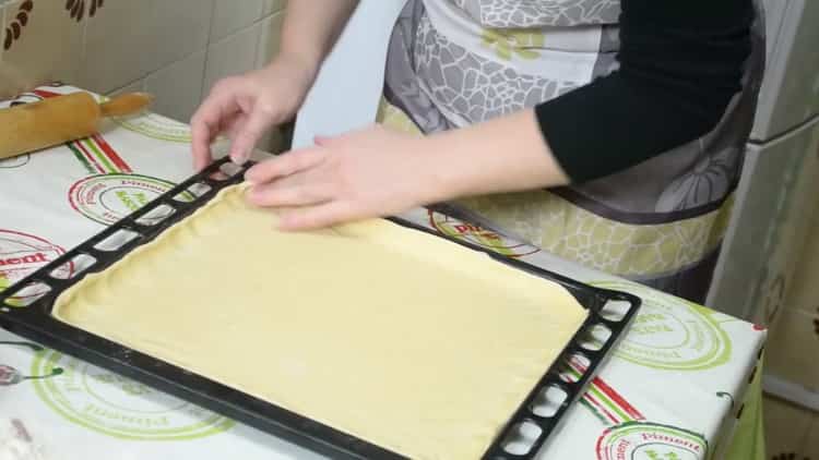 Pour faire une tarte avec du poisson et des pommes de terre, déposez la pâte sur une plaque à pâtisserie