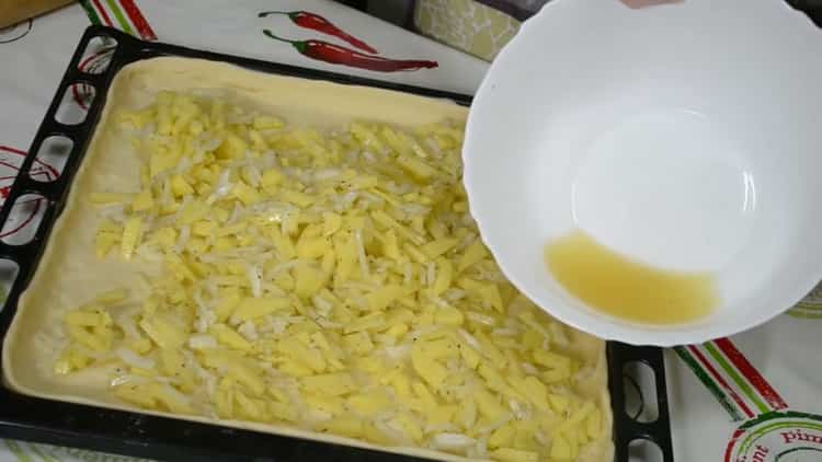 Pour préparer une tarte avec du poisson et des pommes de terre, mettez la garniture sur la pâte