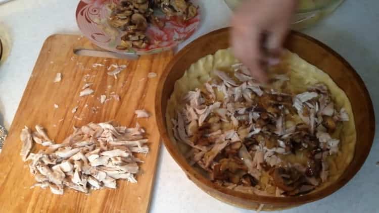 Para preparar el pastel de pollo, ponga el relleno sobre la masa.