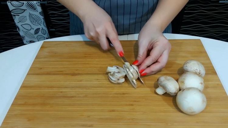 Pour faire une pizza à la maison, hachez les champignons.