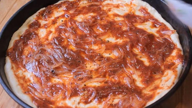 To make pizza in the oven, grease the dough with sauce