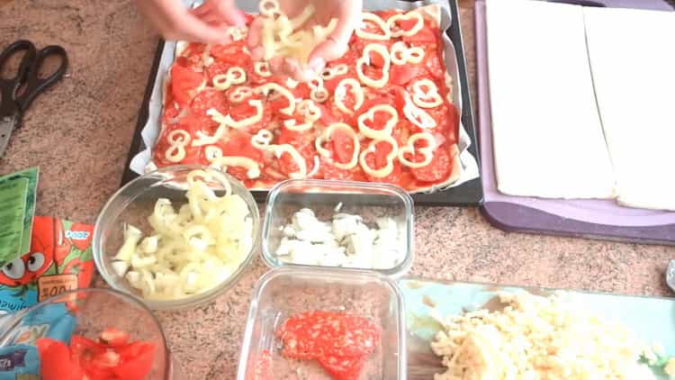 Para hacer pizza de hojaldre en el horno, coloca los ingredientes en la masa