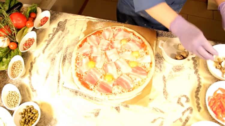 To make carbonara pizza, lay eggs on the dough.