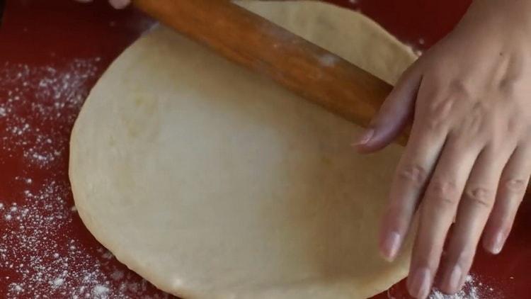 Rol het deeg uit om margarita pizza te maken