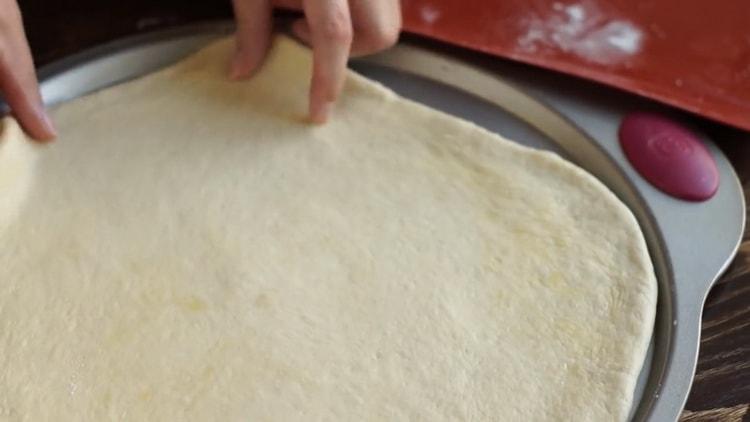 Leg het deeg op de vorm om margarita-pizza te maken