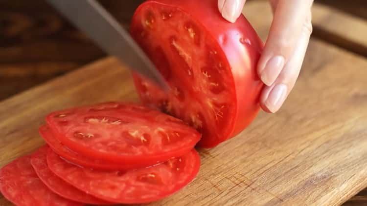 Hak de tomaat om margarita-pizza te maken