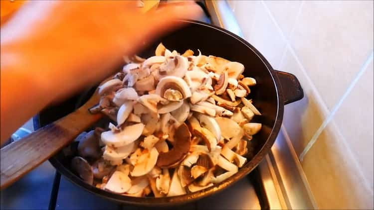 Pour cuire une pizza sur une pâte, faites sauter les oignons et les champignons.