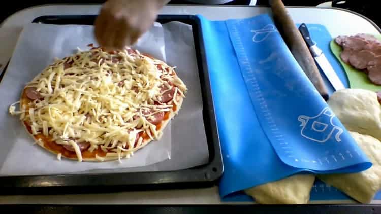 Para hacer pizza de kéfir en el horno, rallar queso