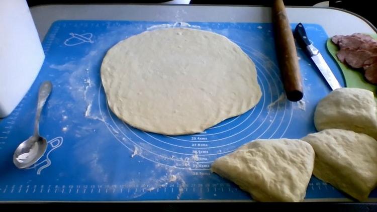 Rol het deeg uit om pizza op kefir in de oven te maken
