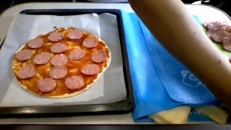 Da biste kuhali pizzu na kefiru u pećnici, narežite kobasicu