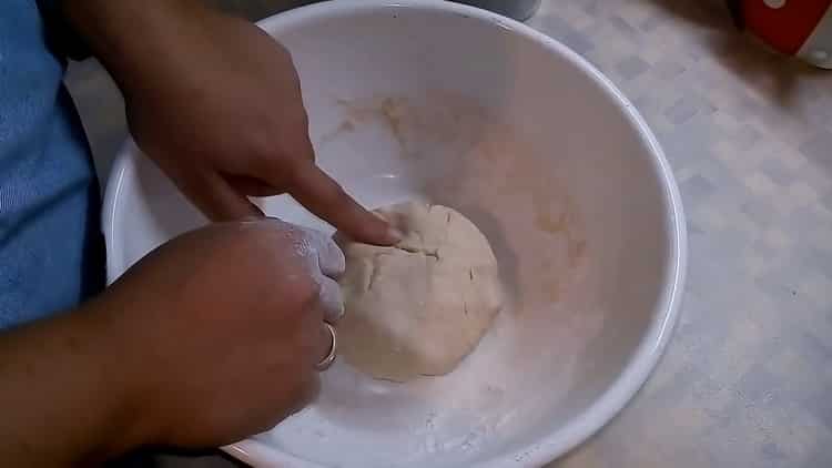 Para hacer pizza con champiñones y queso, amase la masa.