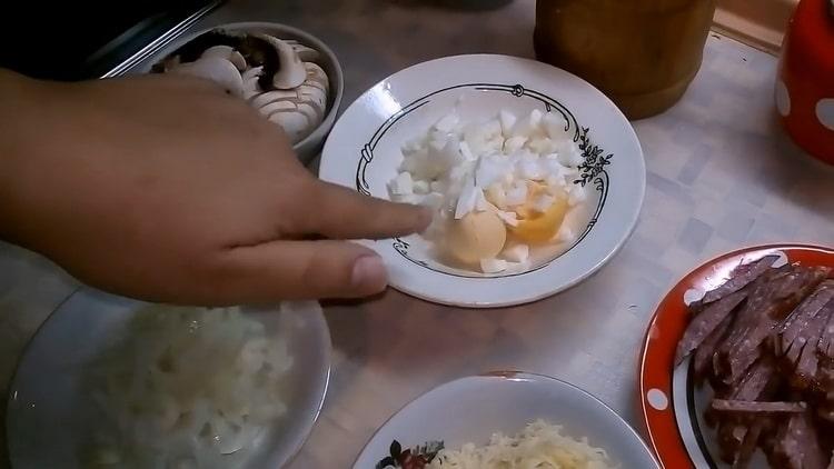 Upang makagawa ng pizza na may mga kabute at keso, i-chop ang pagpuno