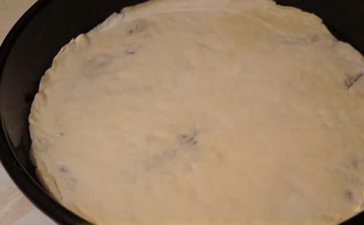 Para preparar pizza con salchichas y queso, ponga la masa en una bandeja para hornear