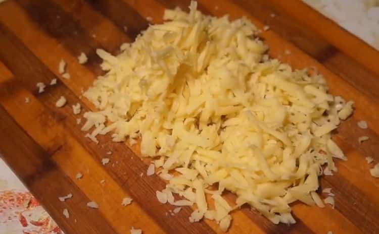 Para hacer pizza con salchichas y queso, ralle el queso