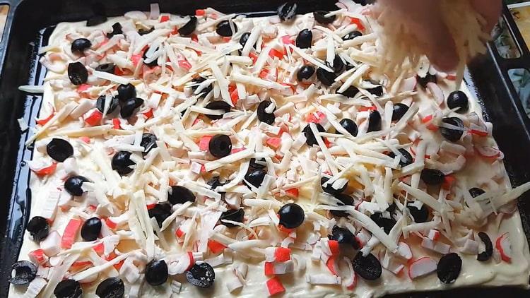 Pour faire des pizzas avec des bâtonnets de crabe, mettez la garniture sur la pâte