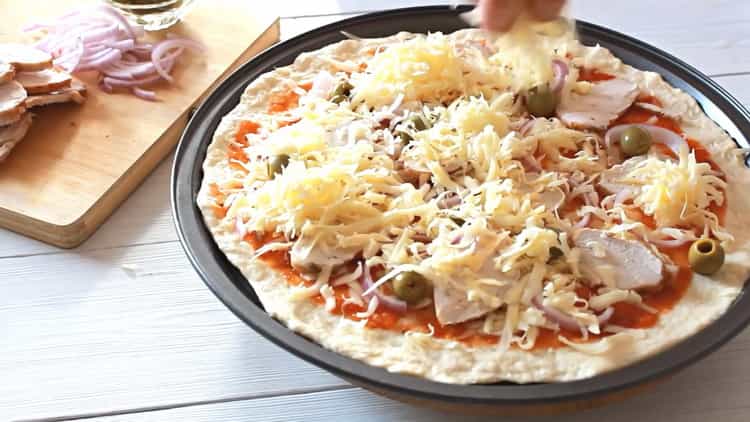 Pour faire une pizza au poulet, fourrez le fromage avec la garniture