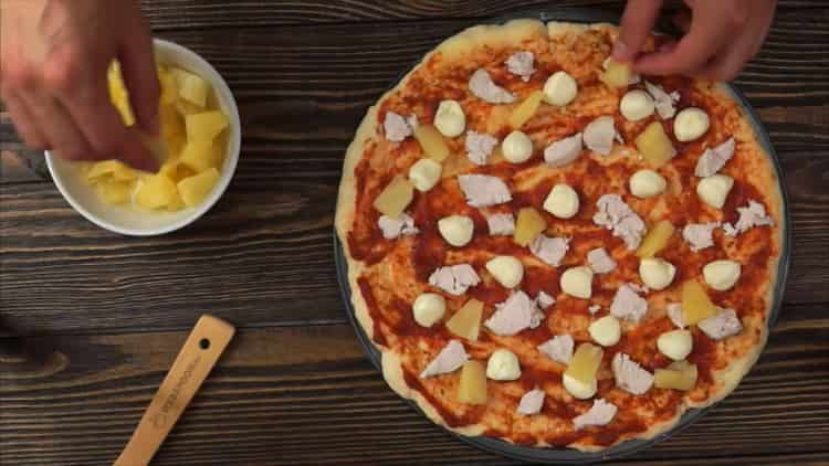 Da biste pripremili pizzu s piletinom i ananasom, stavite nadjev na podlogu