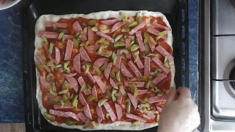 Para hacer pizza con encurtidos, ponga el relleno sobre la masa