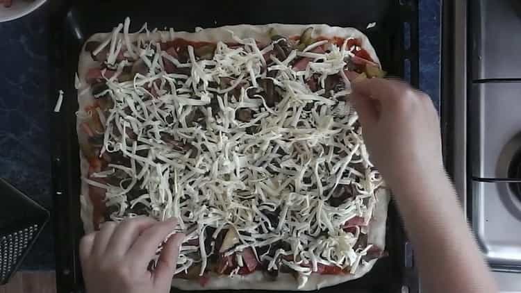 Pon el queso sobre los champiñones para hacer pizza con pepinillos