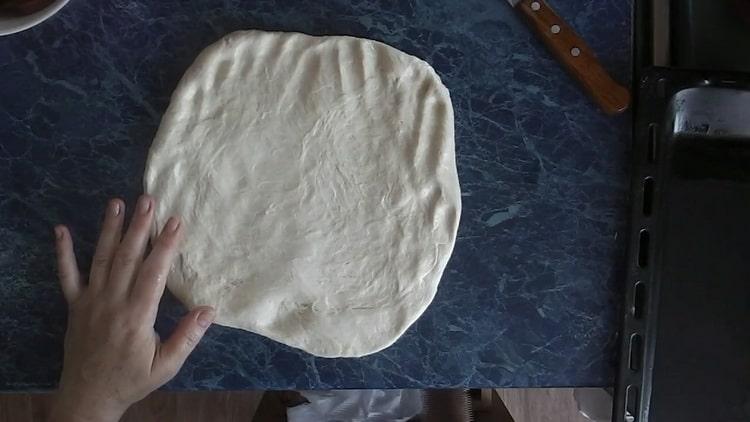 Roll out the dough to make pizza with pickles