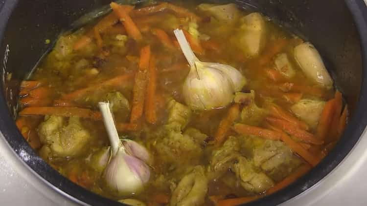 Agregue ajo para cocinar pilaf en una olla de cocción lenta con pollo.