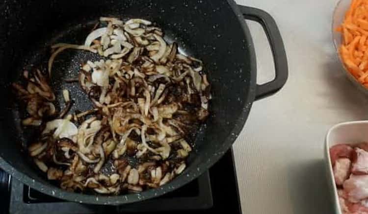 Para cocinar pilaf de cerdo de acuerdo con una receta simple con una foto, fríe la cebolla