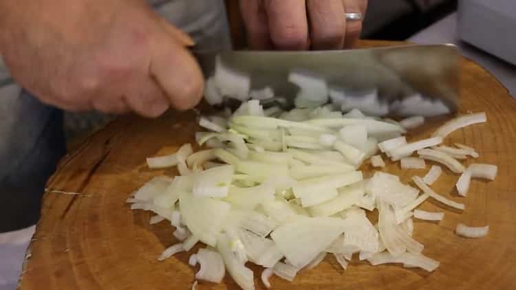 To cook pork pilaf in a pan, chop onion