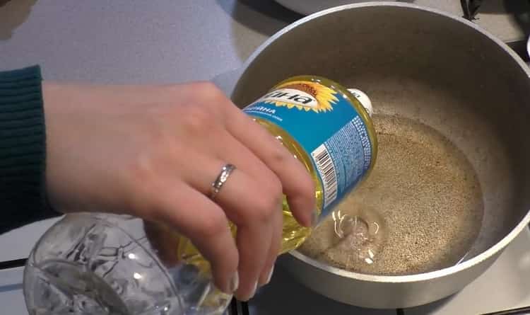 To cook pilaf with chicken in a cauldron, heat a frying pan
