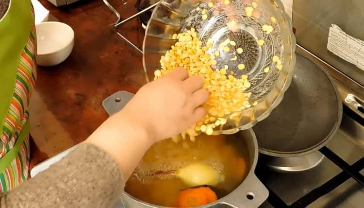Hervir los guisantes para hacer una sopa de pollo magra.
