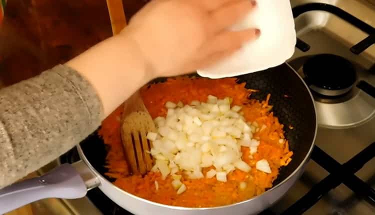 Freír cebollas y zanahorias para hacer sopa de pollo magra.