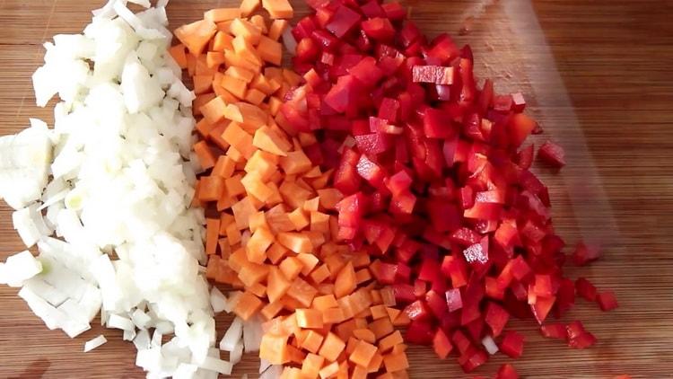 Para cocinar arroz con verduras y pollo, pique las verduras.