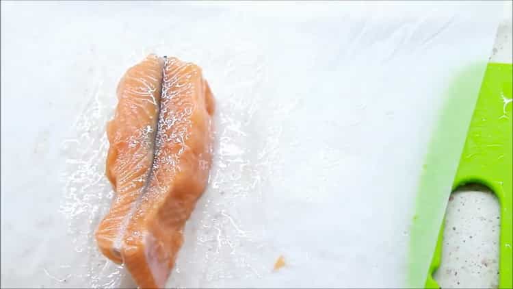 להכנת דגים ברוטב שמנת, הניחו את הדגים על נייר קלף
