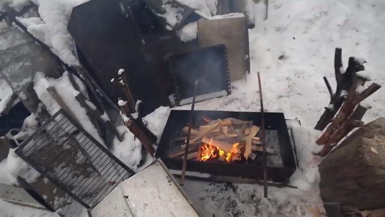 Para hacer pescado ahumado caliente, encienda un fuego